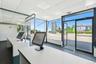 Office space featuring a drop ceiling and expansive windows