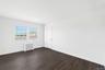 Spare room featuring radiator heating unit and dark wood-type flooring
