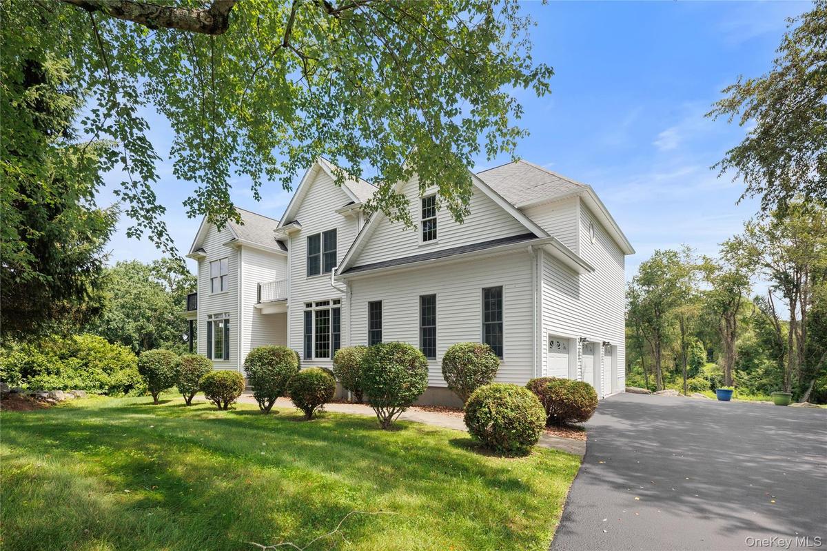 This elegant Colonial showcases timeless architecture, manicured grounds, an expansive driveway, and exceptional curb appeal, creating a welcoming set