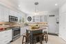 The heart of the home, this beautifully appointed kitchen features crisp white Shaker-style cabinetry with elegant glass-front displays, stainless ste