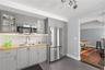 Adding to the versatility and convenience of the lower-level living space, a thoughtfully appointed kitchenette features stylish gray-toned and glass-
