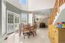 The space is further enhanced by expansive windows that fill the room with natural light, while doors leading to the deck seamlessly extend the dining