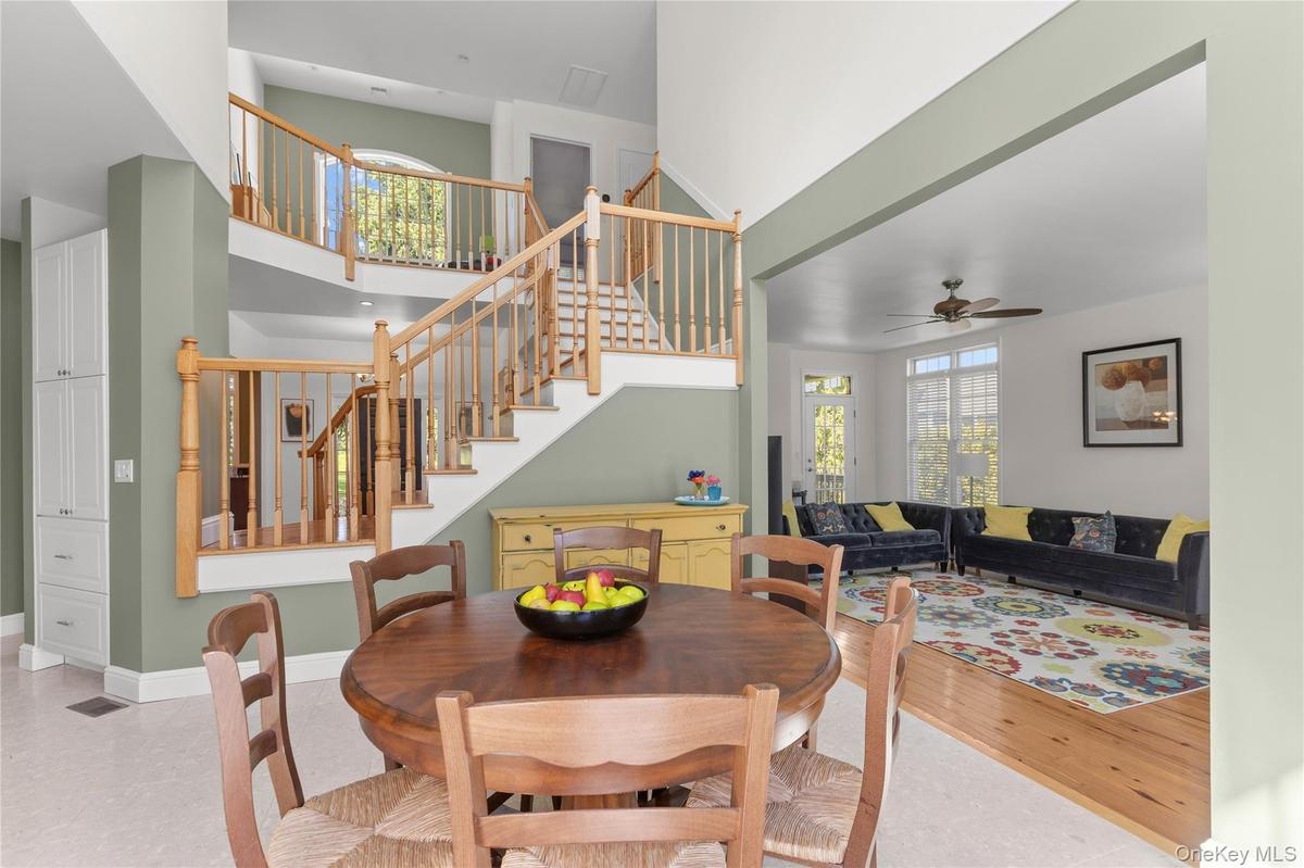 The inviting kitchen dining area showcases high ceilings and gleaming light-colored tile floors, creating a bright, welcoming setting for morning coff