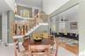 The inviting kitchen dining area showcases high ceilings and gleaming light-colored tile floors, creating a bright, welcoming setting for morning coff