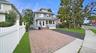 Two-story residence with a covered porch, dormer windows, and a paved driveway