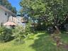 Expansive backyard featuring a large tree, a detached shed, and a two-story deck with white railings