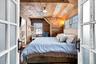 Primary bedroom with reclaimed wood-paneled walls and ceiling