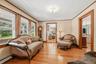 Living room with hardwood floors, natural wood trim, and large windows providing plenty of natural light.