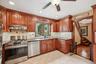 Kitchen with granite countertops, tile backsplash, stainless steel appliances and abundant wood cabinetry.