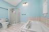 Primary bathroom with a jetted soaking tub, separate shower and vaulted ceiling.