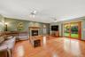 Spacious family room featuring hardwood floors, a fireplace, arched windows, and sliding glass doors leading to the backyard.