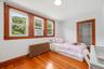 Bedroom with hardwood floors, three windows and generous closet space.