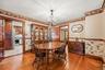 Dining room featuring hardwood floors, natural wood trim, and direct access to the kitchen.