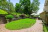 Landscaped backyard with paver walkways, retaining walls, and an outdoor seating area.