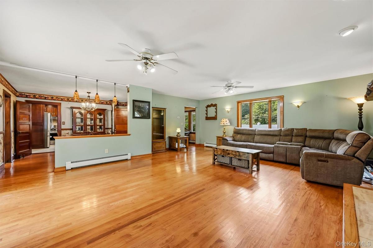 Spacious family room with hardwood floors and an open layout connecting to the kitchen and dining area.