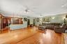 Spacious family room with hardwood floors and an open layout connecting to the kitchen and dining area.