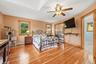 Primary bedroom with hardwood floors, vaulted ceiling, ample closet space and direct access to the private bathroom.