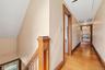Upper-level hallway with Hardwood flooring, wood trim, wood staircase, and recessed lighting