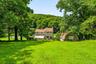 Expansive backyard with mature trees and detached garage.