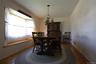 Hardwood-style flooring, a window bench with wood trim, and a classic chandelier