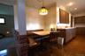 Kitchen with wood-finish cabinetry, solid surface countertops, and patterned floor tile