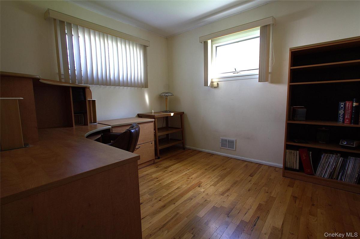 Hardwood flooring, painted walls, and multiple windows