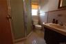 Bathroom featuring a stand-up shower with a frosted glass enclosure, single vanity with integrated sink, toilet, and a window with a valance