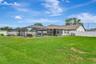 View of Rear of Home, Lot is almost 1/2 Acre; Large Backyard, Fully Fenced with Double Gates, Custom Pool Cage & Pool; Seating Area; Summer Kitchen; E