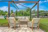 View of Outdoor Summer Kitchen; Expansive Covered Rear Lanai; Custom Pool with Sun Shelf, Fire and Waterfall feature; Pavered Floor; Additional Seatin
