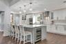 Remodeled Kitchen with upgraded custom cabinets with crown molding trim and lighting; elevated hardware and fixtures; quartz countertops; two-tone Cab