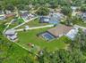 View of Backyard, Playground, Two Covered Open-Air Structured Storage areas with Concrete Pads, Firepit, and Shed. Bring the Boat- Bring the Toys - Th