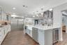 Remodeled Kitchen with upgraded custom cabinets with crown molding trim and lighting; elevated hardware and fixtures; quartz countertops; two-tone Cab