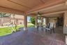 Covered patio extending across the ground level of the residence.