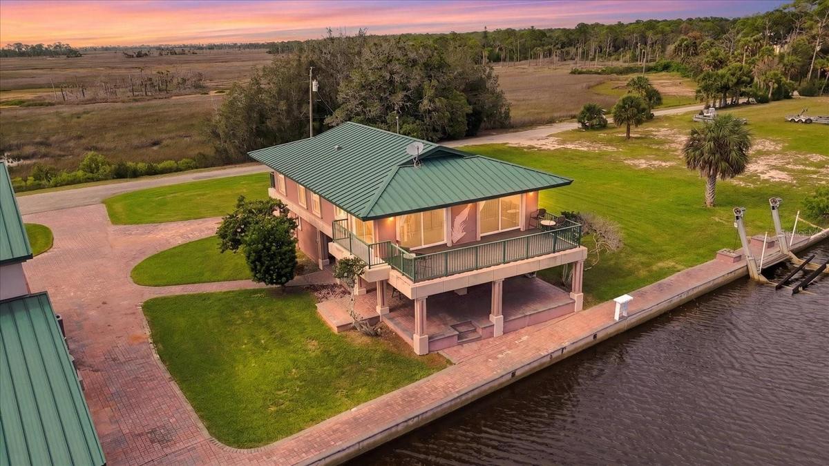 Twilight aerial showing the residence, waterfront, and surrounding grounds.