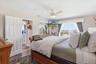 Primary bedroom with large windows and waterfront exposure.