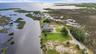 Sweeping aerial view across the property, coastal wetlands, and Gulf of America beyond.