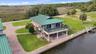 Aerial perspective highlighting the residence, seawall, lawn, and water frontage.