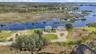 High aerial view toward the Gulf of America across the undeveloped coastal marshlands.