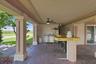 Wide view of the covered bar and adjoining outdoor living space.