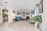 Living space featuring a built-in fireplace, custom shelving, crown molding, and carpeted flooring