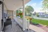 Covered porch with herringbone-patterned paver flooring, white railings, and recessed lighting