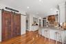 A custom walk-in pantry, beautifully appointed with reclaimed wood doors, provides additional storage while adding warmth and character to the space.