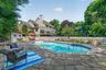A heated in-ground pool is beautifully framed by tasteful stonework and surrounded by ample space for outdoor furniture.