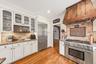 Enter an inviting eat-in gourmet kitchen, thoughtfully designed with abundant workspace, ample storage, and charming architectural details.