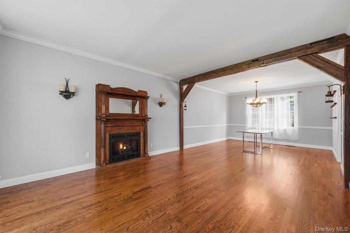 The spacious living room flows seamlessly into a formal dining room, elegantly defined by rich wood accents.