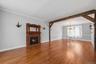 The spacious living room flows seamlessly into a formal dining room, elegantly defined by rich wood accents.