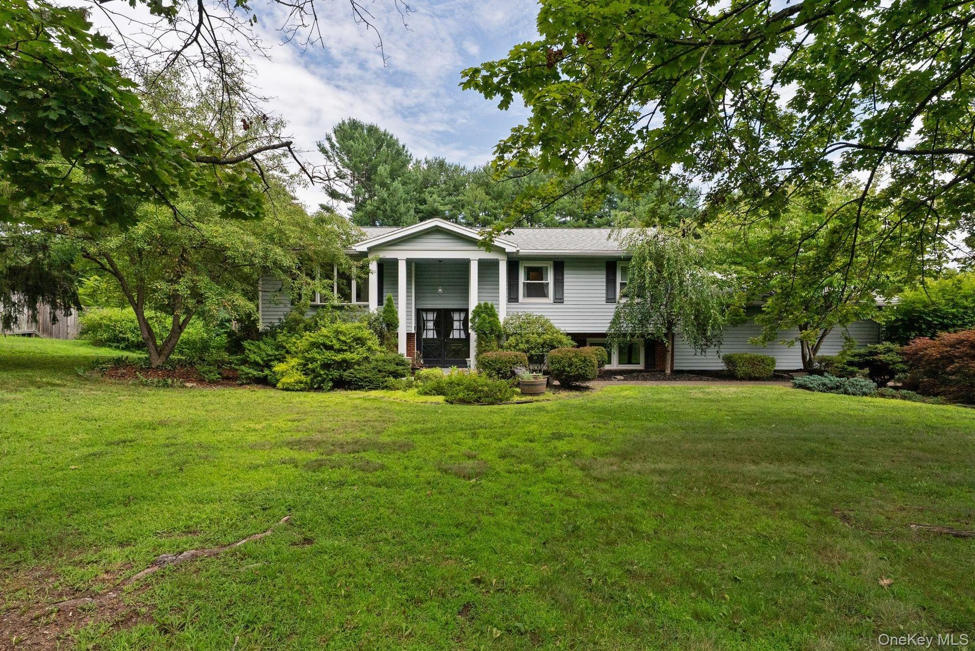 Expansive front lawn with mature trees and established landscaping
