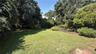 Expansive park like yard surrounded by mature trees and established landscaping