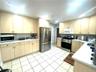 Light-toned cabinetry with matching upper and lower storage, white countertops, tile flooring, and a subway tile backsplash