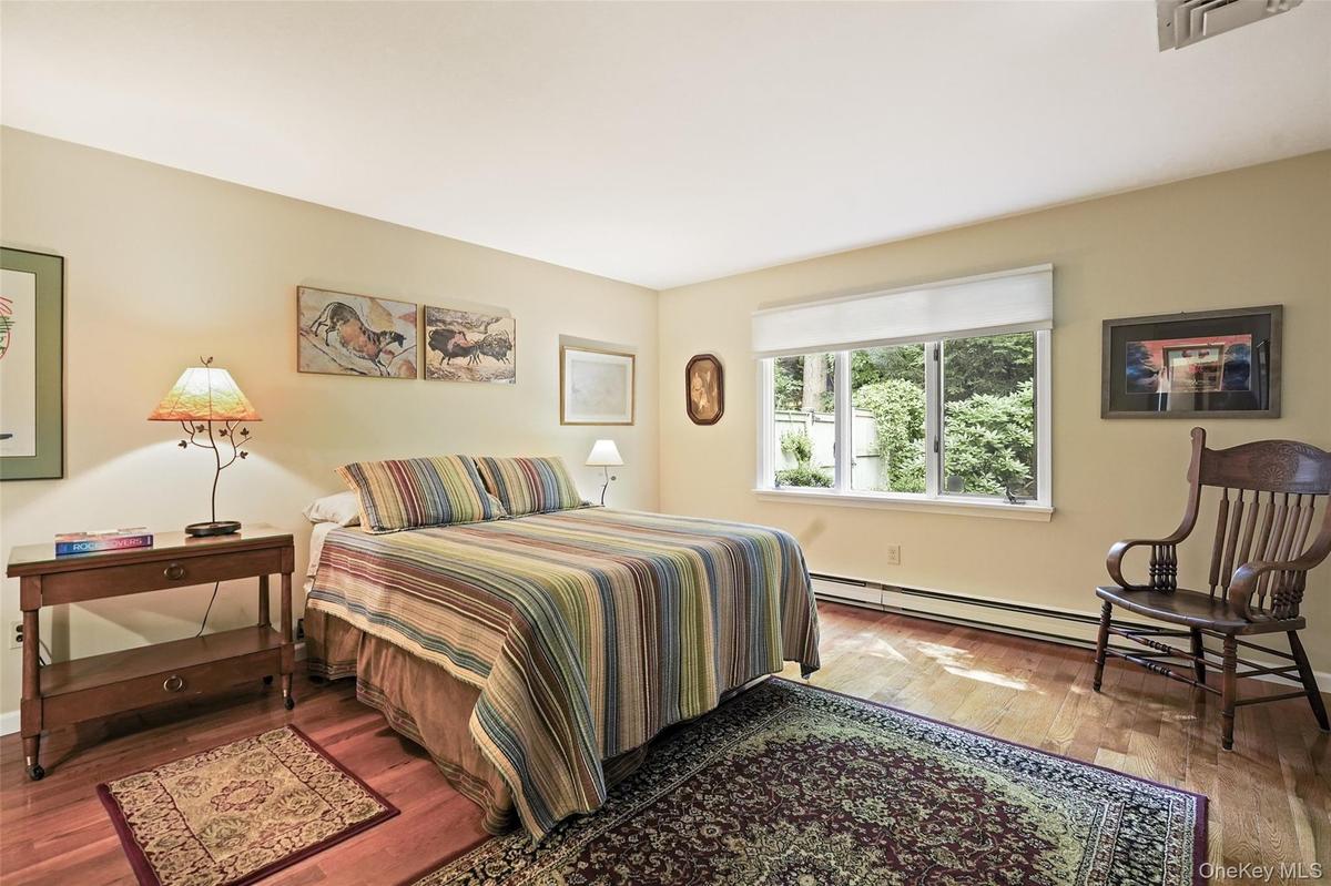 Spacious primary bedroom with window facing private backyard